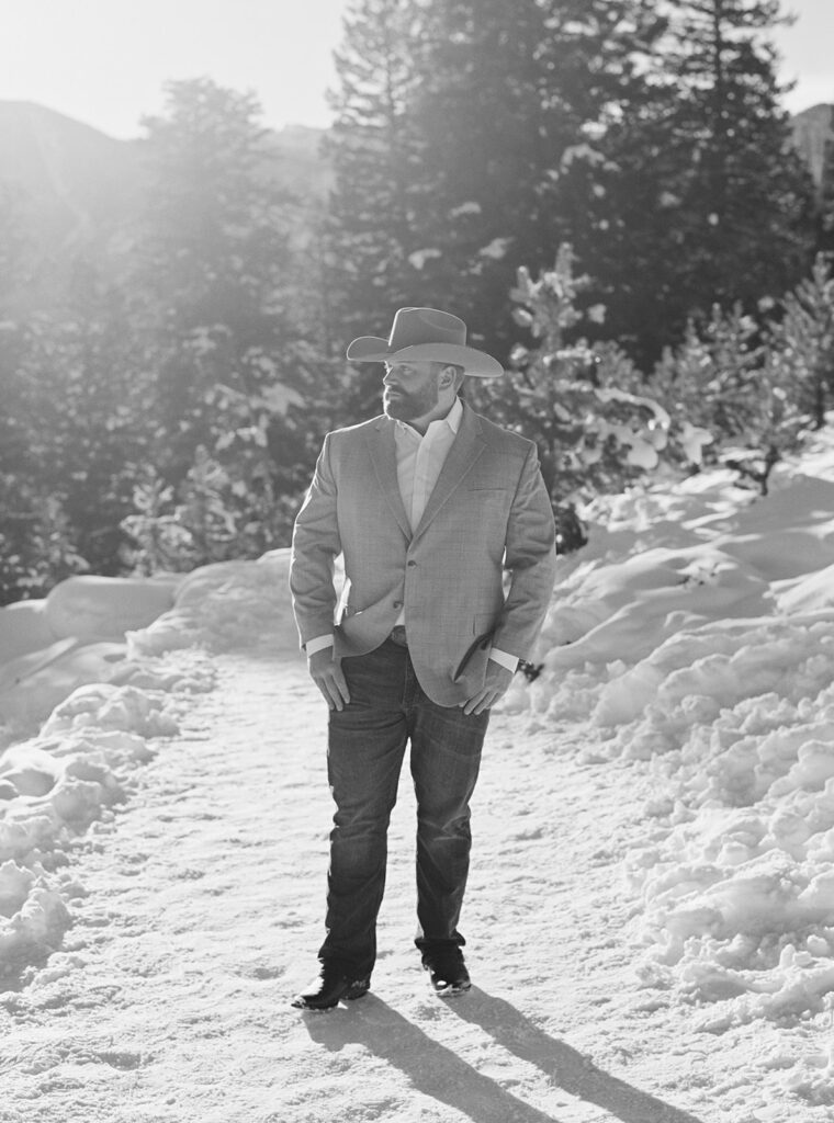 Cozy winter engagement session in Vail, Colorado captures couple smiling with stunning mountain view.