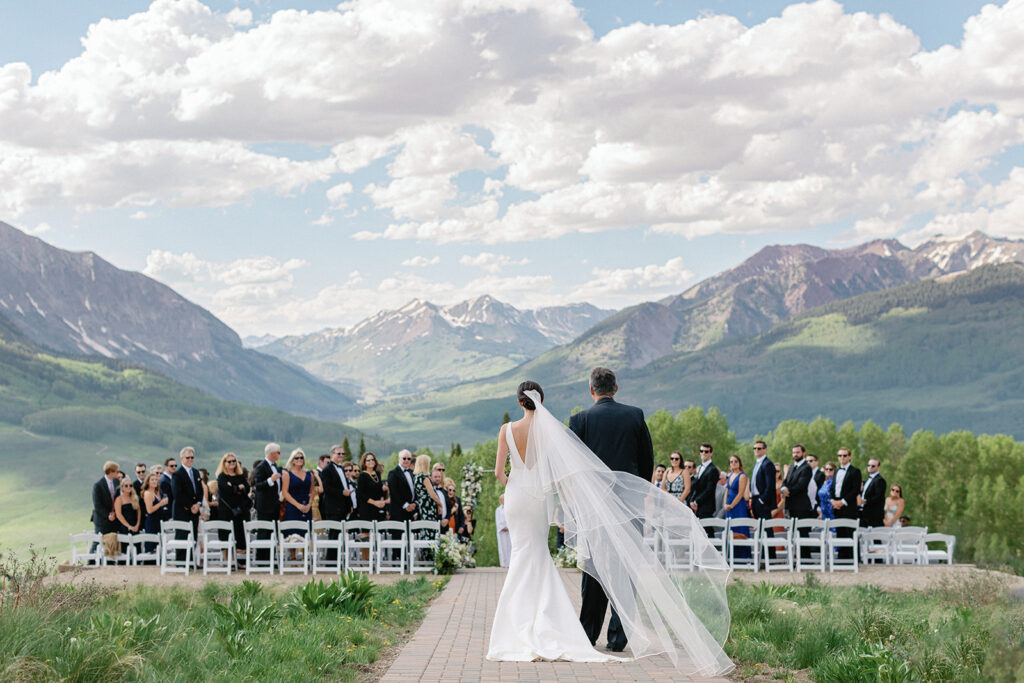 A panoramic view of the wedding reception, set against a picturesque mountain backdrop.