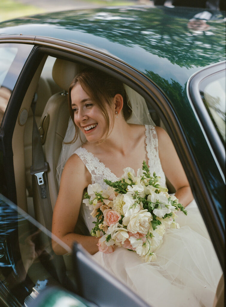 bride arriving in car holding bouquet at private estate wedding