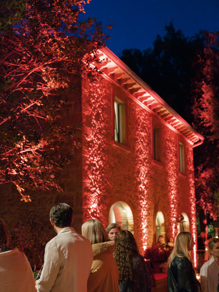 Outdoor evening gathering at Engage Summit Tuscany with villa lighting