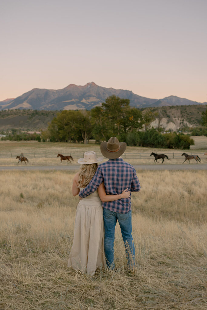 couple watching horses at sunset at Mountain Sky Guest Ranch