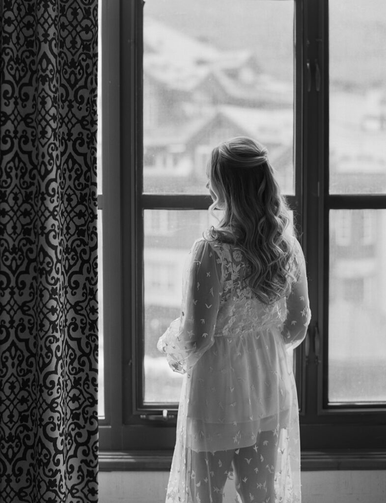 bride getting ready by window at Park Hyatt Beaver Creek