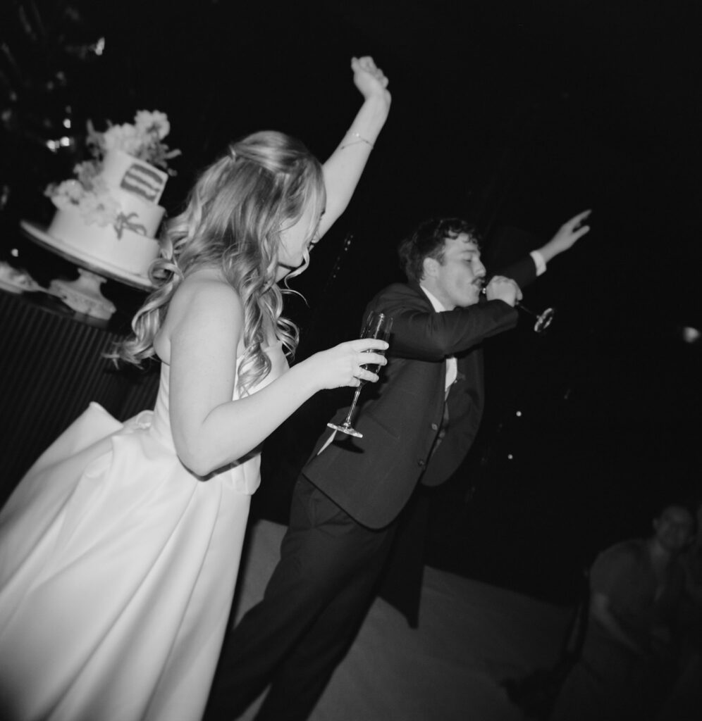 bride and groom cake cutting with champagne
