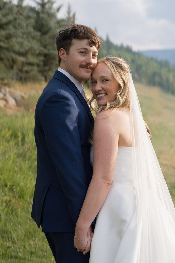 bride and groom running through meadow at Beaver Creek wedding
