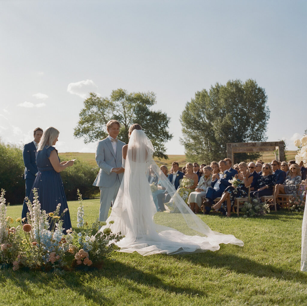 bride walking down aisle at lakeside ceremony Catamount Ranch