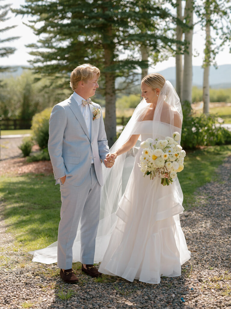 bride holding white bouquet with groom at Catamount Ranch