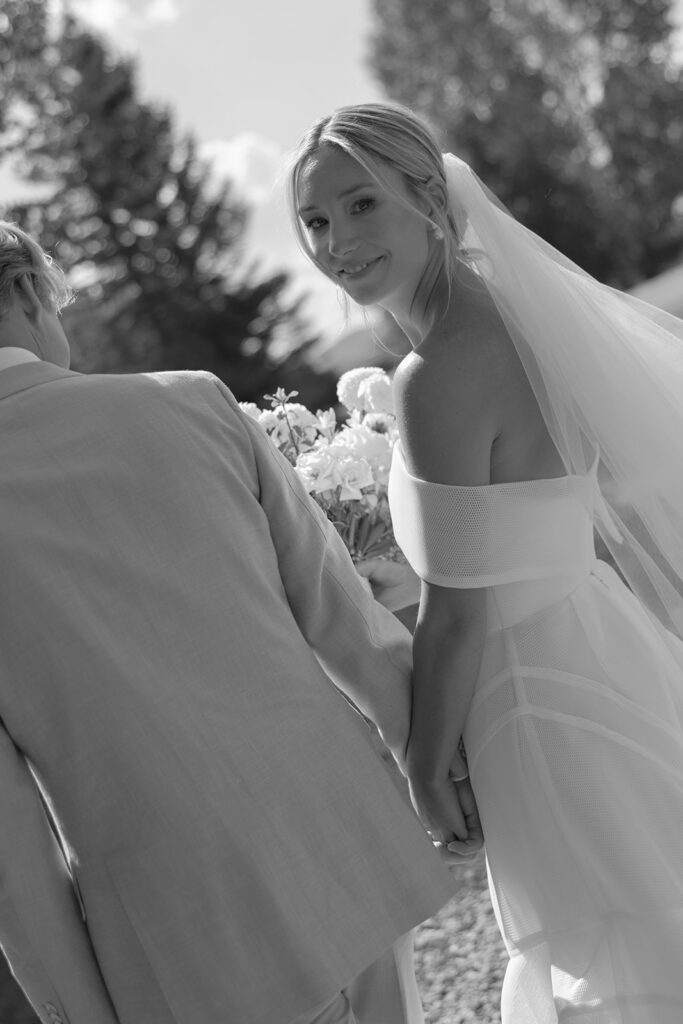 bride smiling through veil holding bouquet at Colorado wedding