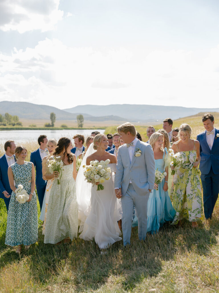 wedding party walking along lake at Catamount Ranch Colorado
