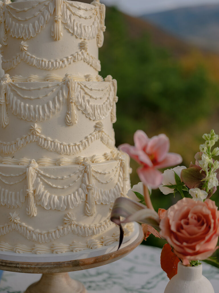 Wedding cake detail with mountain backdrop in Aspen