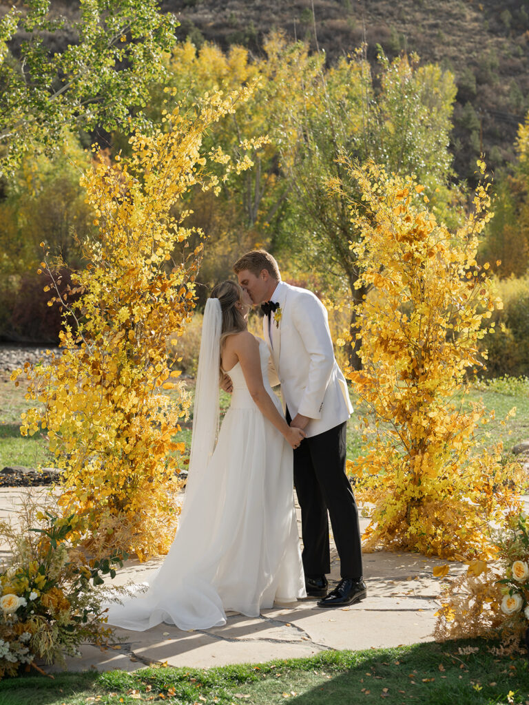 couple kissing between golden aspen trees at fall Aspen wedding