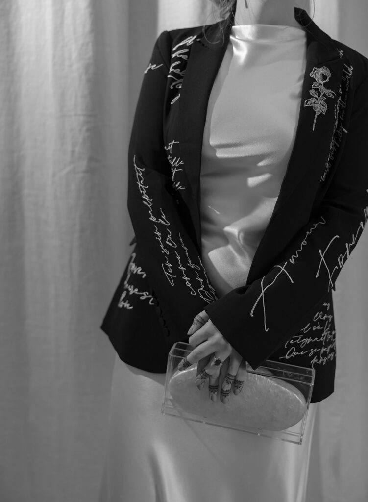 bride wearing black jacket over dress with modern accessories