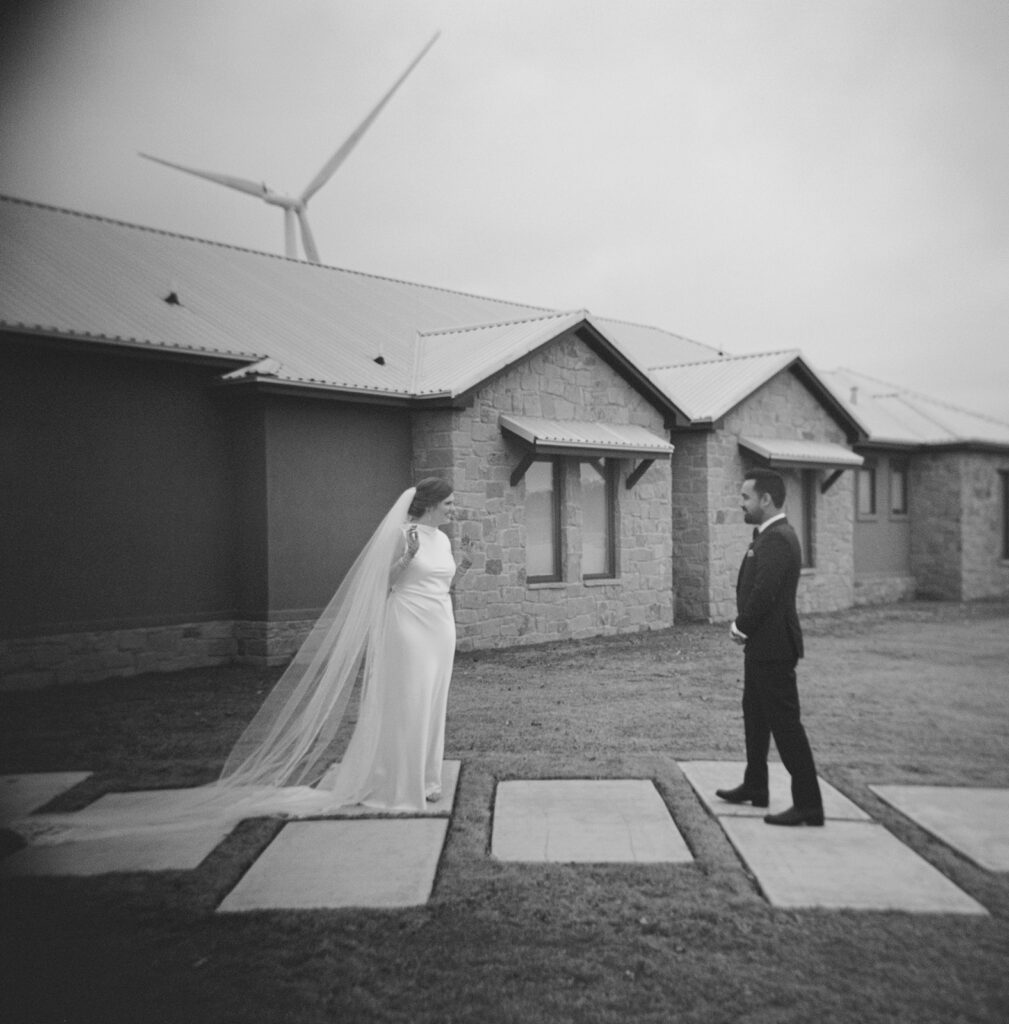 bride and groom first look outside ranch house black and white