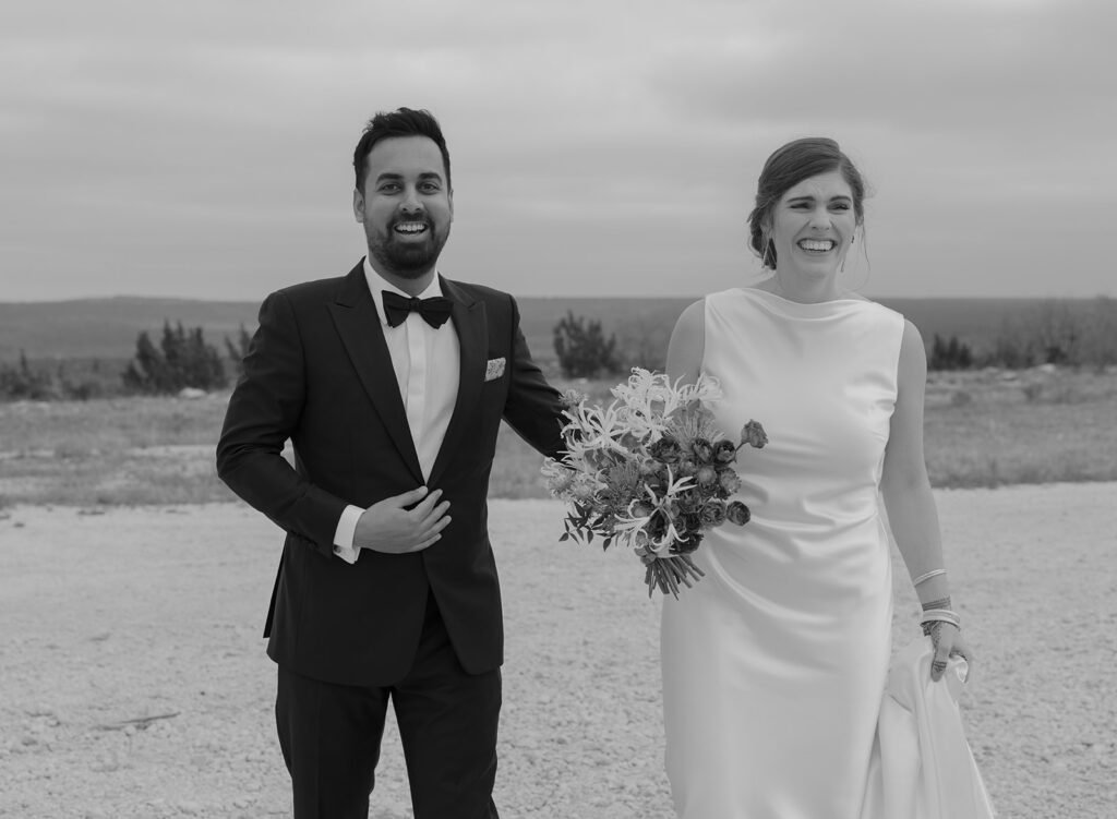 bride and groom holding hands in Texas ranch field